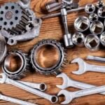 tools and old auto parts on wooden background